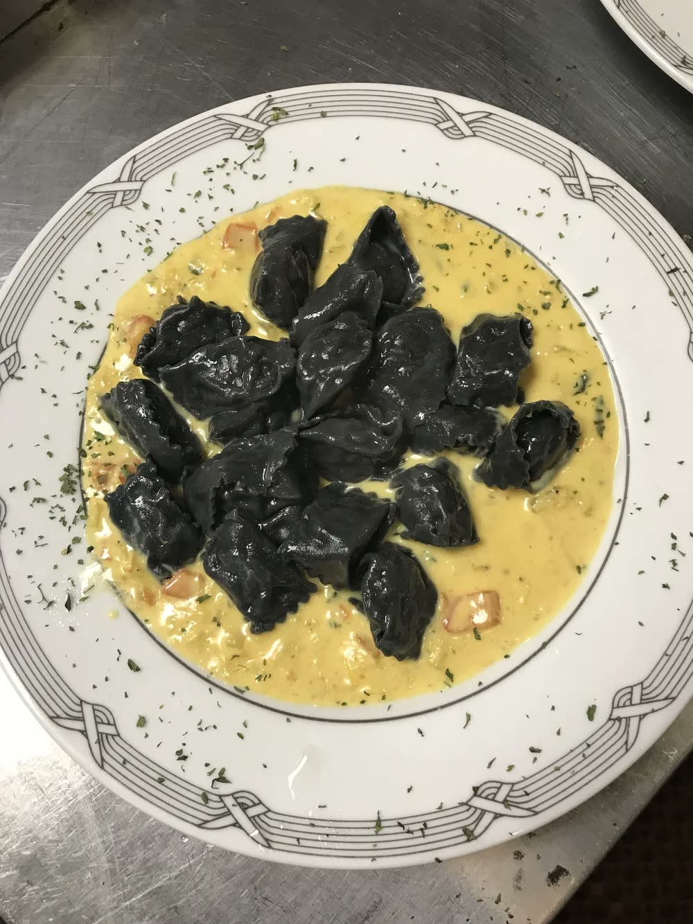 Black squid-ink ravioli in a saffron cream
